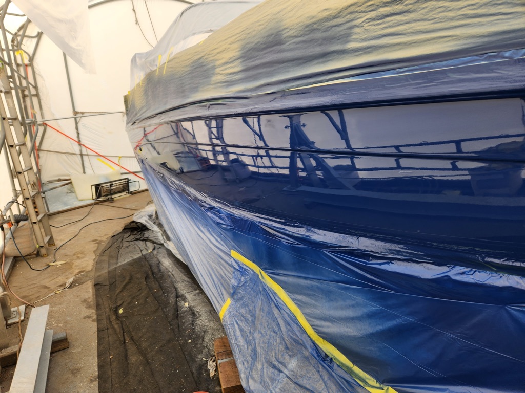 Blue boat hull paint detail with masking tape