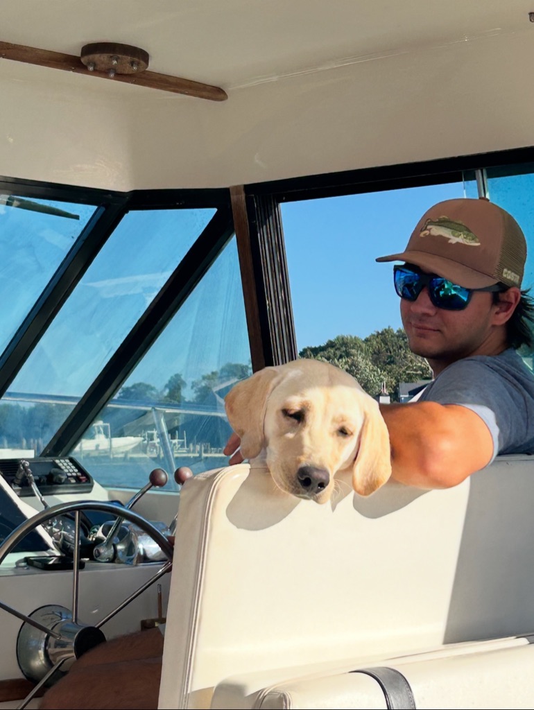 Matthew Hoyt with dog on boat